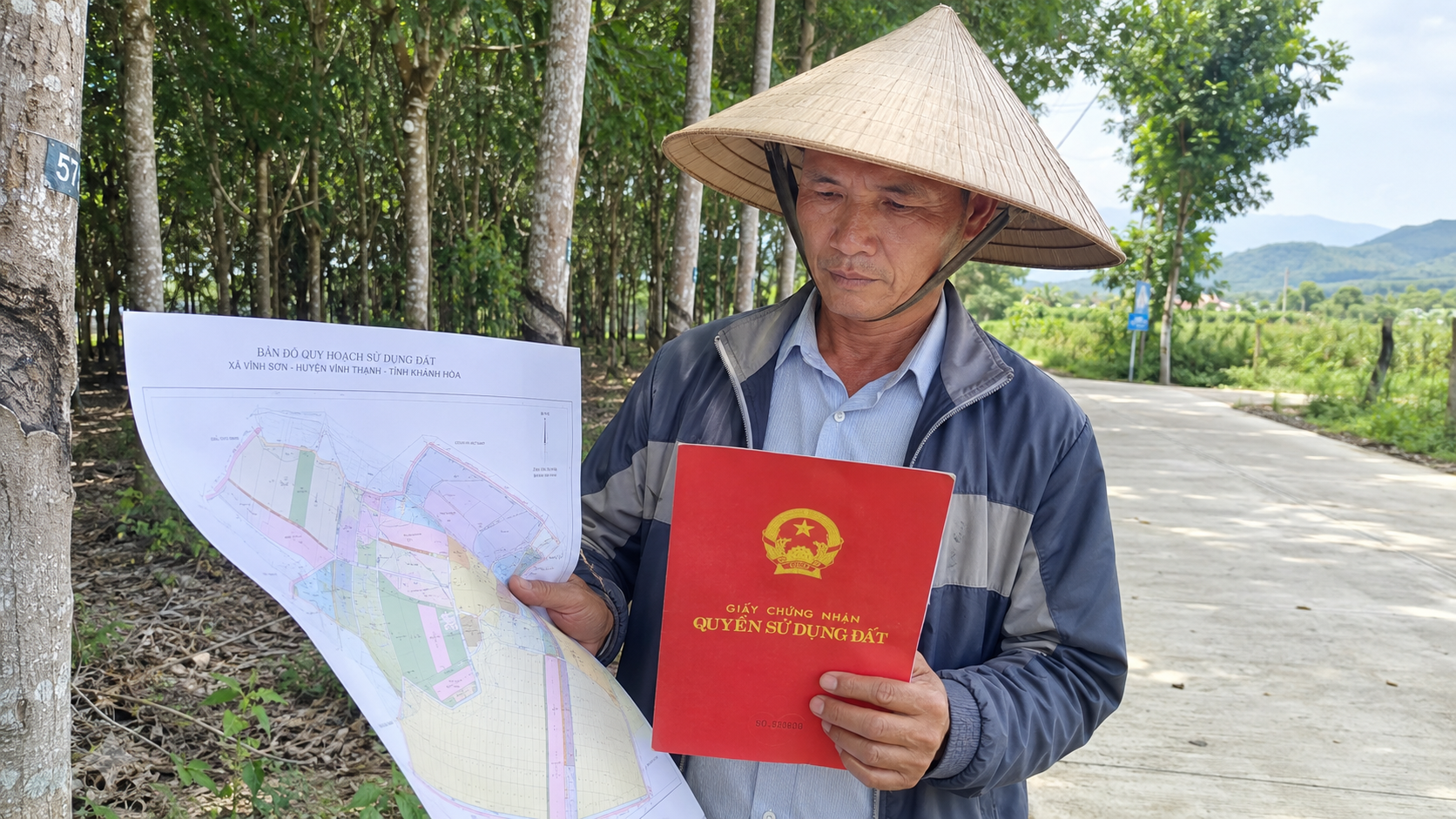 Nông dân xem bản đồ quy hoạch và cầm sổ đỏ trên đất nông nghiệp Khánh Hòa